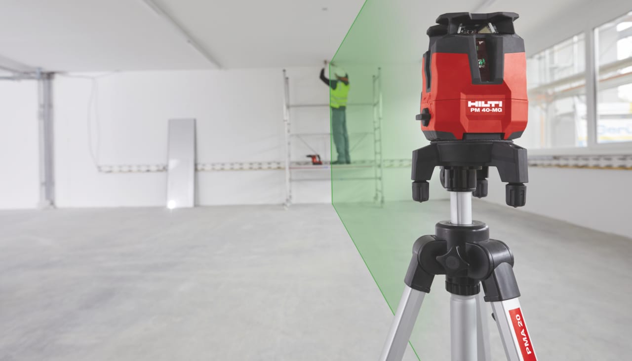 Grøn laserstråle fra rotationslaser lyser tværs over et lokale