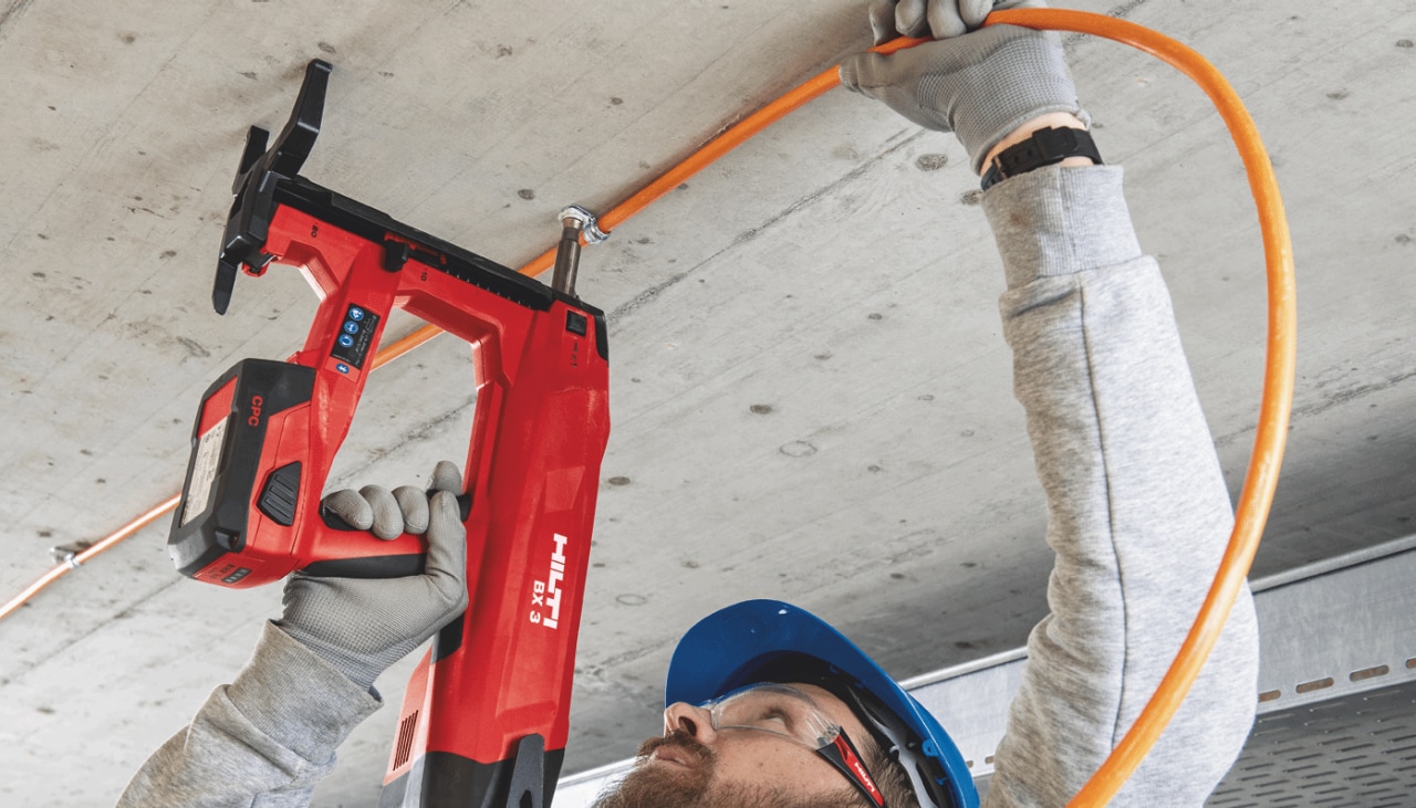Person skyder elementer i et loft med BX 3 boltepistol