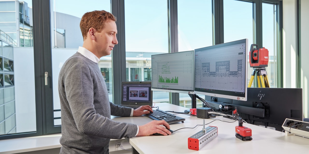 Mand står ved computer og ser på designprogrammer