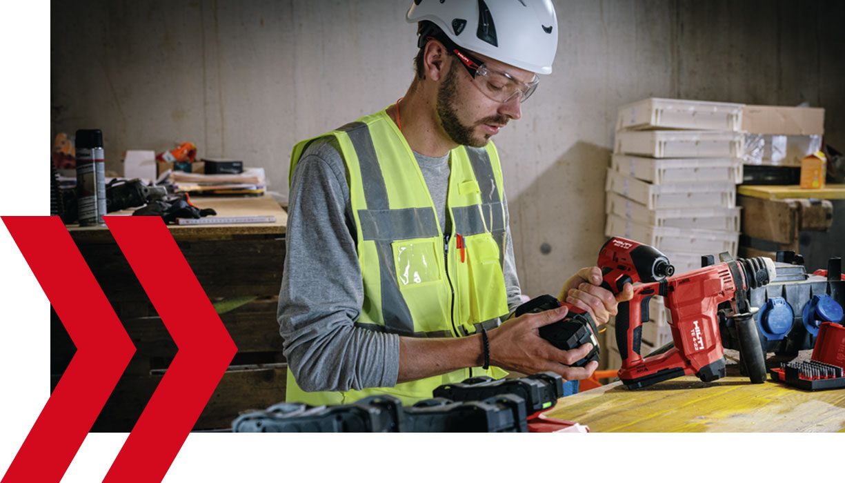 Person skifter batteri på boremaskine