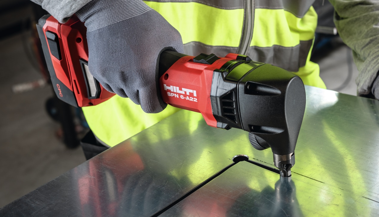 man using cordless nibbler on metal