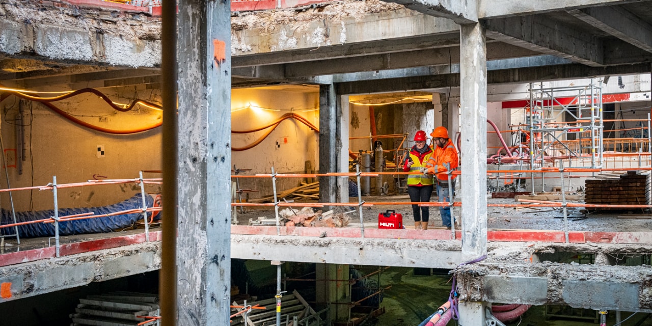 To personer taler sammen i en bygning på en byggeplads